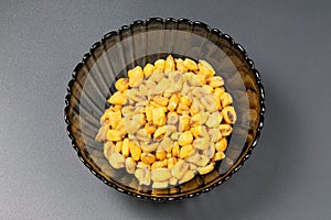 Roasted corn nuts in plate on dark background