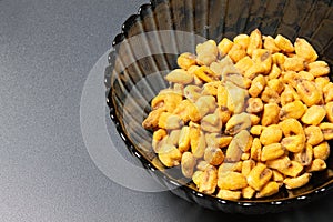 Roasted corn nuts in plate on dark background