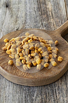 Roasted corn snack. Corn nuts with sauce on wood background