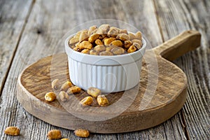 Roasted corn snack. Corn nuts with sauce on wood background