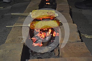 The roasted corn sticked with a stick is on top