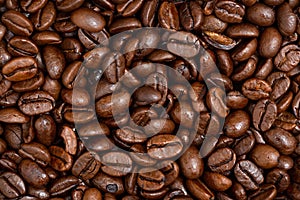 Roasted dark coffee beans background from close up.