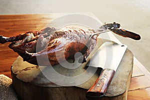 Roasted duck and Chineses knife on tamarind wood cutting board