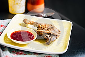 Roasted Duck Leg with Spices, Lemon Juice, Mustard and Berry Sauce on Dark Background