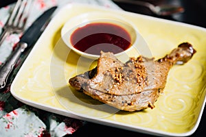 Roasted Duck Leg with Spices, Lemon Juice, Mustard and Berry Sauce on Dark Background