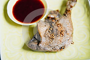 Roasted Duck Leg with Spices, Lemon Juice, Mustard and Berry Sauce on Dark Background