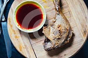 Roasted Duck Leg with Spices, Lemon Juice, Mustard and Berry Sauce on Dark Background