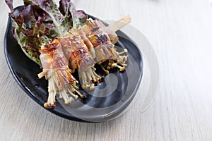 Roasted enoki mushrooms with bacon . Japanese food