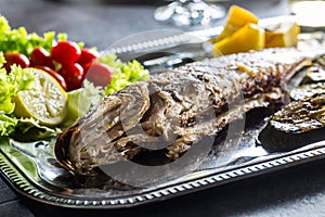 Roasted fish on dish with fresh and grilled vegetable