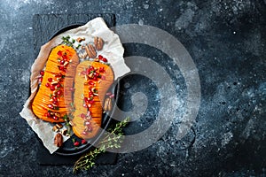 Roasted hasselback butternut squash pumpkin with thyme, pecan and pomegranate. Thanksgiving dinner recipe. photo