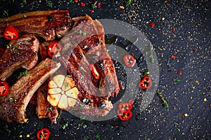 Roasted lamb cutlets ribs with garlic and herbs on stone background