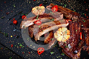 Roasted lamb cutlets ribs with garlic and herbs on stone background