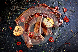 Roasted lamb cutlets ribs with garlic and herbs on stone background