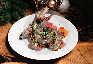 Roasted lamb ribs with herbs, pomegranate seeds and grilled bell peppers