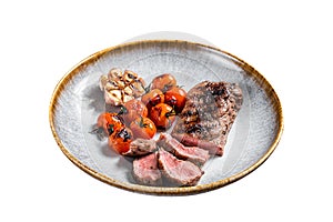 Roasted Lamb tenderloin meat in plate with grilled tomato and garlic, mutton sirloin fillet steak. Isolated on white