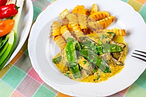 Roasted liver in curry sauce with green sweet pea pod and french fries