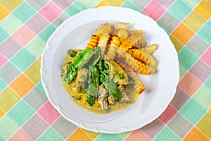 Roasted liver in curry sauce with green sweet pea pod and french fries