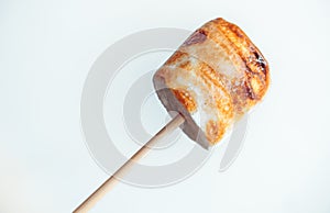 Roasted marshmallows on a skewer on white background