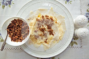 Roasted meat in a bowl . A bowl of white ceramic salt and pepper . Traditional azerbaijani khingal with force-meat on the