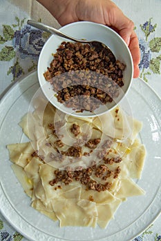 Roasted meat in a bowl . A bowl of white ceramic salt and pepper . Traditional azerbaijani khingal with force-meat on the