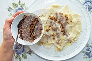 Roasted meat in a bowl . A bowl of white ceramic salt and pepper . Traditional azerbaijani khingal with force-meat on the