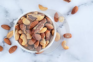 Roasted mixed nuts in white ceramic bowl