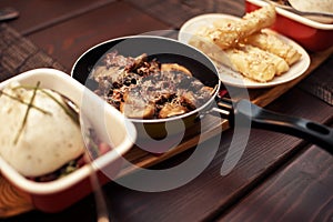 Roasted mushrooms with onion in frying pan over wooden background