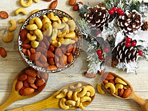 Roasted Natural Almond Nuts Badam and Cashew in a porcelain bowl and Christmas home decoration.