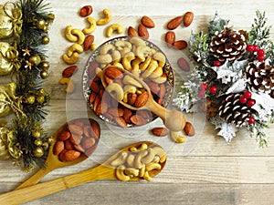 Roasted Natural Almond Nuts Badam and Cashew in a porcelain bowl and Christmas home decoration.