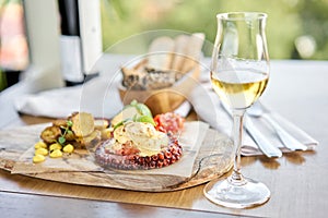 Roasted octopus BBQ and Baked potato with a glass of Grapa. Wooden plate. Restaurant menu photo