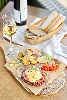 Roasted octopus BBQ and Baked potato with a glass of Grapa. Wooden plate. Restaurant menu photo