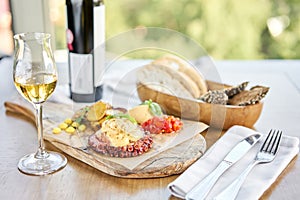 Roasted octopus BBQ and Baked potato with a glass of Grapa. Wooden plate. Restaurant menu photo