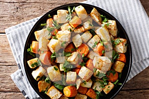 Roasted organic celery root and carrots close-up on a plate. Horizontal top view