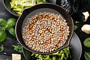 Roasted pine nuts on a cast iron pan ready to be sprinkled over pasta