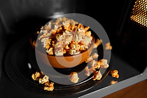 Roasted popcorn in a clay brown dish stand in the microwave