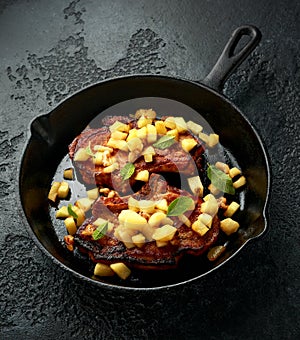 Roasted Pork chops with caramelized apples, walnuts and sage in a cast iron pan
