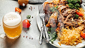 Roasted pork knuckle eisbein with sauerkraut and beer. Oktoberfest menu, dish of German and Czech cuisine