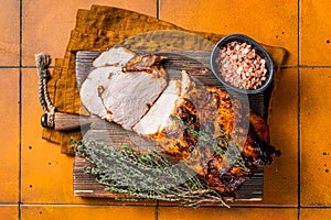 Roasted Pork Meat Roll with garlic sliced on cutting board. Orange background. Top view