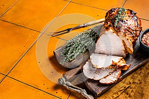 Roasted Pork Meat Roll with garlic sliced on cutting board. Orange background. Top view. Copy space