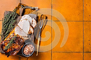 Roasted Pork Meat Roll with garlic sliced on cutting board. Orange background. Top view. Copy space