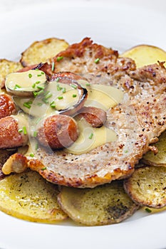 roasted pork meat with sausage, mustard sauce and roasted potatoes