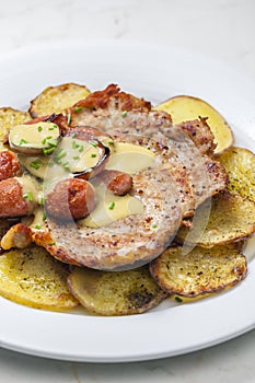 roasted pork meat with sausage, mustard sauce and roasted potatoes