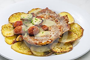 roasted pork meat with sausage, mustard sauce and roasted potatoes