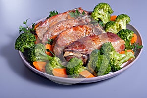 Roasted pork ribs on plate with broccoli