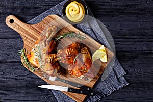 Roasted pork shanks on a wood board, top view