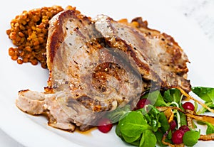 Roasted pork shin with lentils, greens and berries