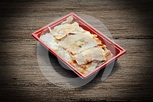 Roasted pork topping on japanese rice in plastic tray