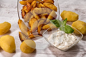Roasted potatoes with herbal sauce in glass dish