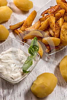 Roasted potatoes with herbal sauce in glass dish