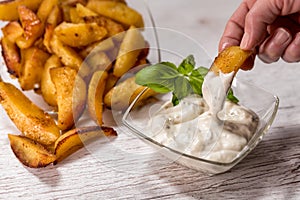 Roasted potatoes with herbal sauce in glass dish